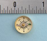 Large Military Special Forces Survival Button Compass next to an inch scale